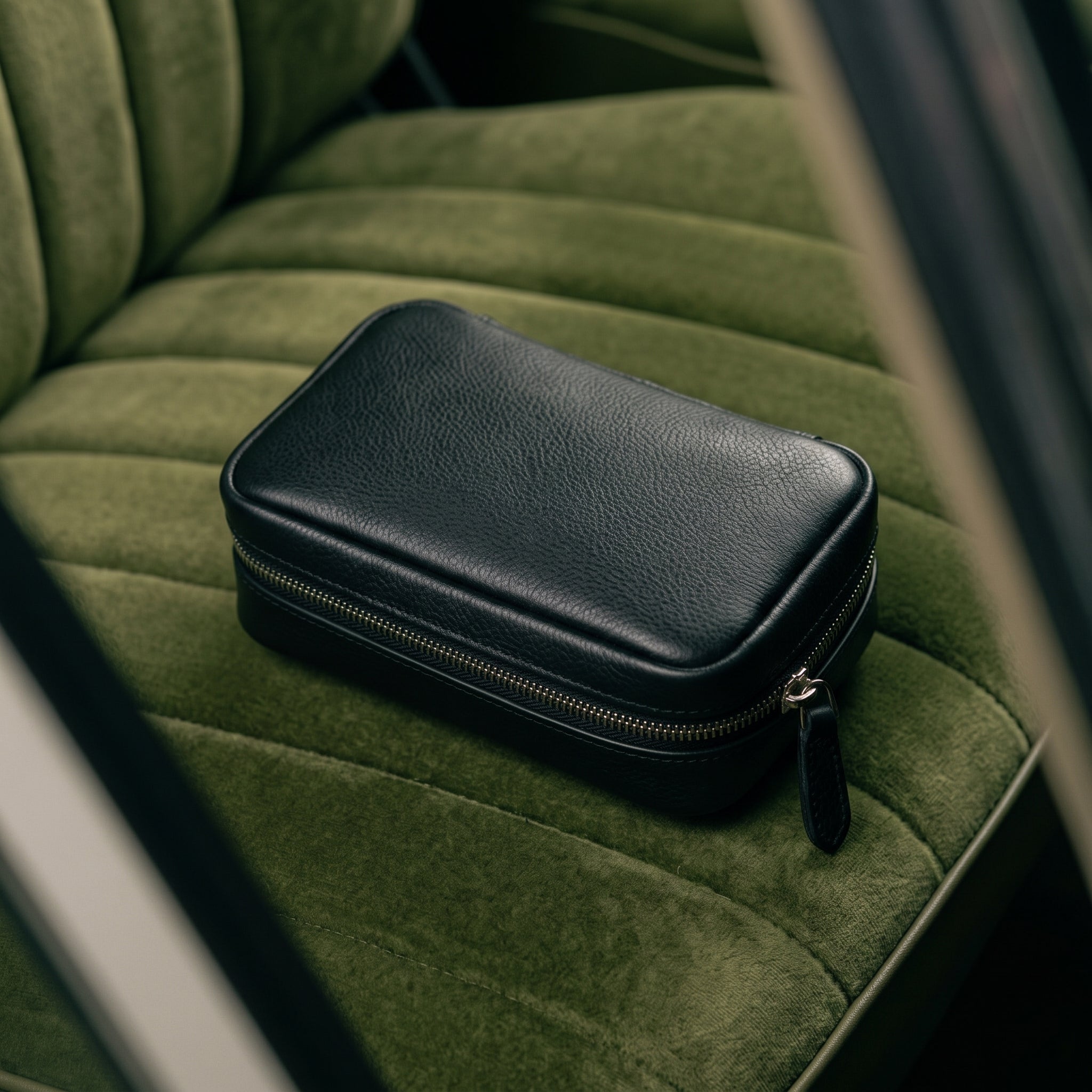 Geschlossene schwarze Tasche auf einem olivgrünen Sitz